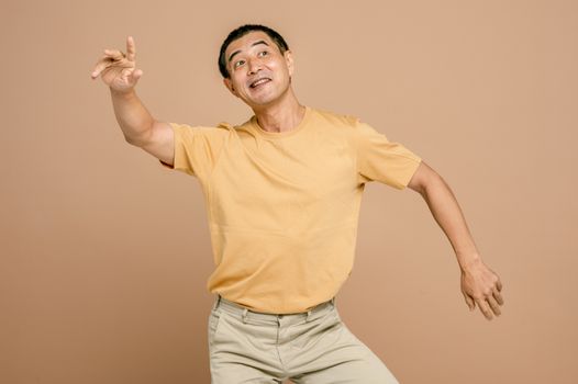 演播室里，一名身穿黄色衬衫的开朗男子正欢快地跳舞，动作十分活泼
