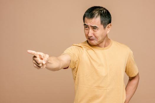 一名成年男子表情沮丧，愤怒地用手指着棕色背景