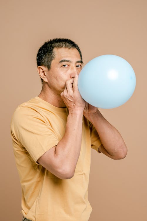 Free Man Blowing Up a Balloon Stock Photo