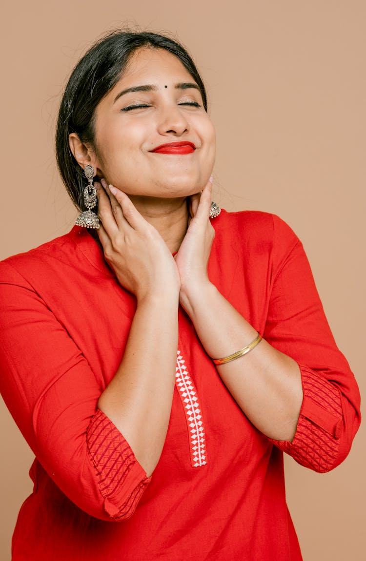 A Woman Posing With Both Hands On Her Neck