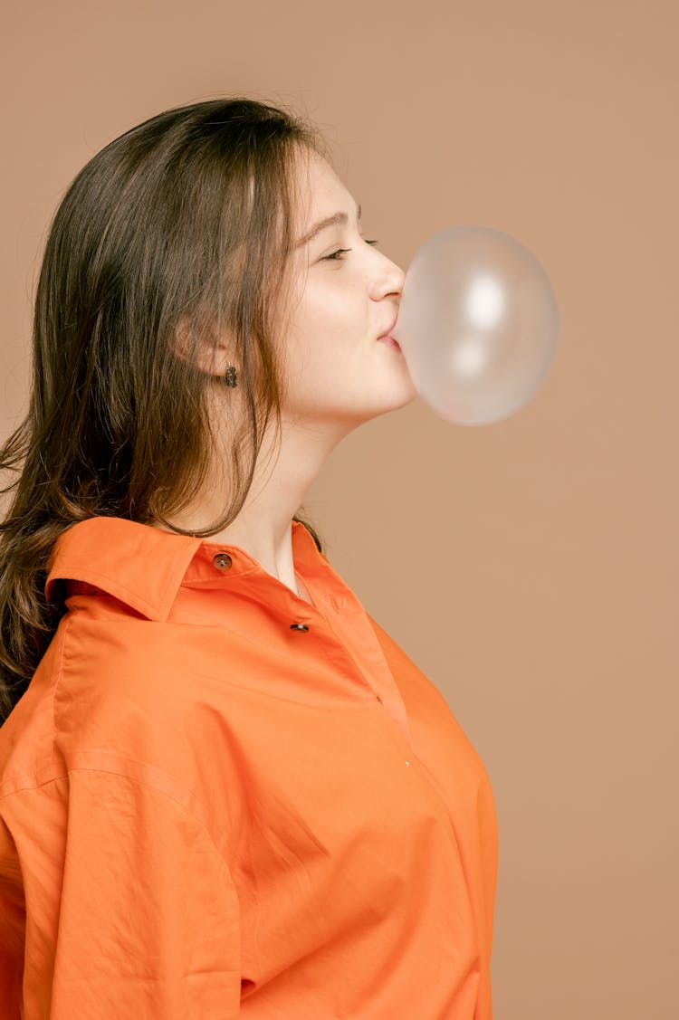 A Pretty Woman Blowing A Bubble Gum