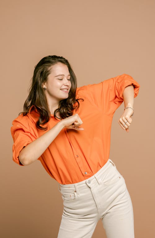 A Pretty Woman in Orange Shirt Dancing 