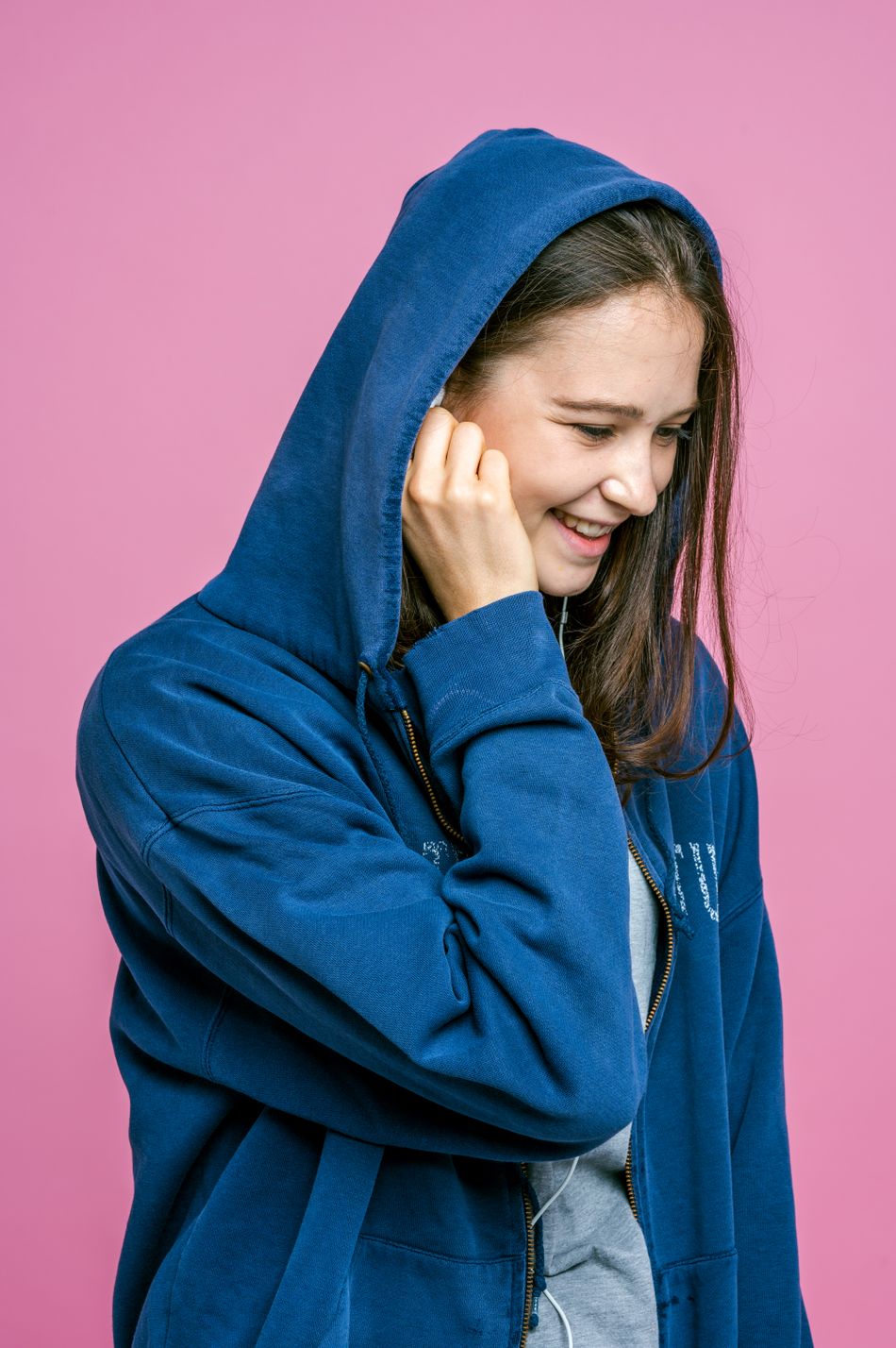 Shopper in a blue hooded sweatshirt against a pink backdrop — Ketut Subiyanto on Pexels