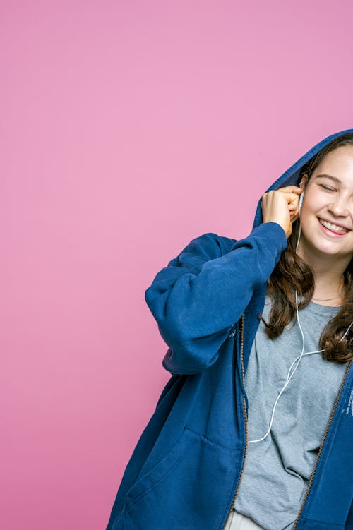 Woman in Blue Hoodie on a Pink Background