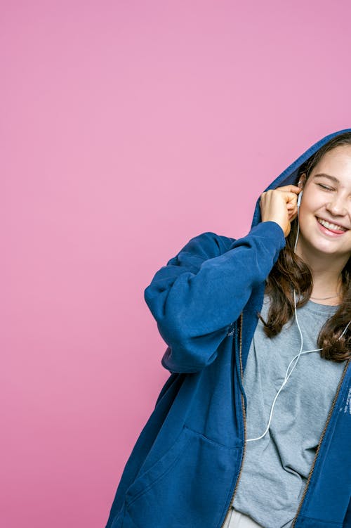 Mujer En Sudadera Con Capucha Azul Sobre Un Fondo Rosa