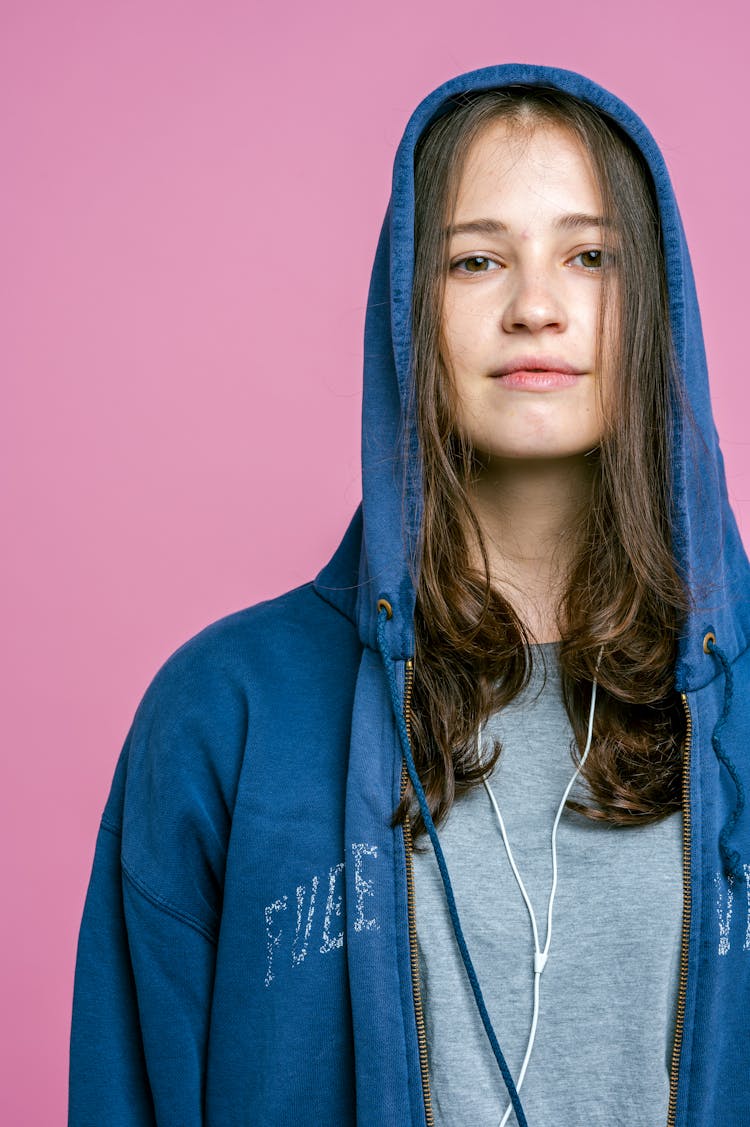 Girl Wearing An Oversized Hoodie With A Hood On Her Head 