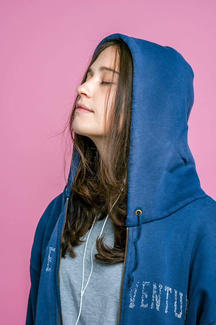 Girl Wearing An Oversized Hoodie With A Hood On Her Head 