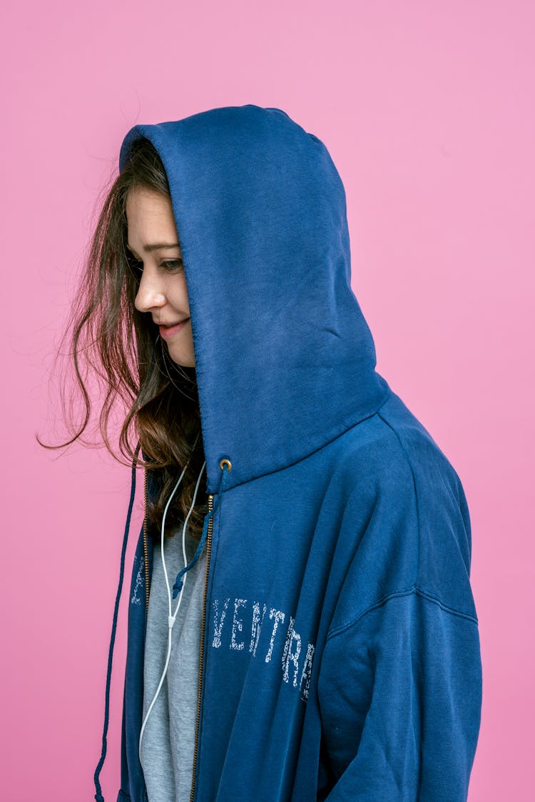 Girl Wearing An Oversized Hoodie With A Hood On Her Head 