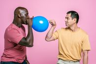 Man in Yellow Crew Neck T-shirt Holding Blue Balloon