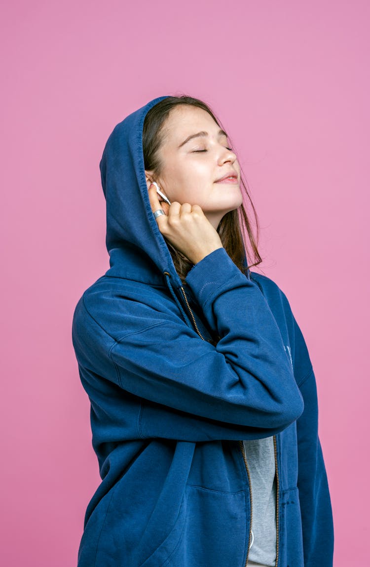 Girl Wearing a Hood On Her Head And Listening To Music On Earphones