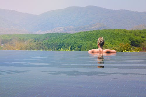 Woman Half Submerge Facing on Mountain