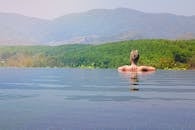 女士们在俯瞰郁郁葱葱山脉的无边泳池中放松身心，非常适合度过宁静的假期