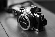 木制表面上老式奥林巴斯相机的优雅黑白照片