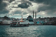 Boat floating on river in old city on overcast day
