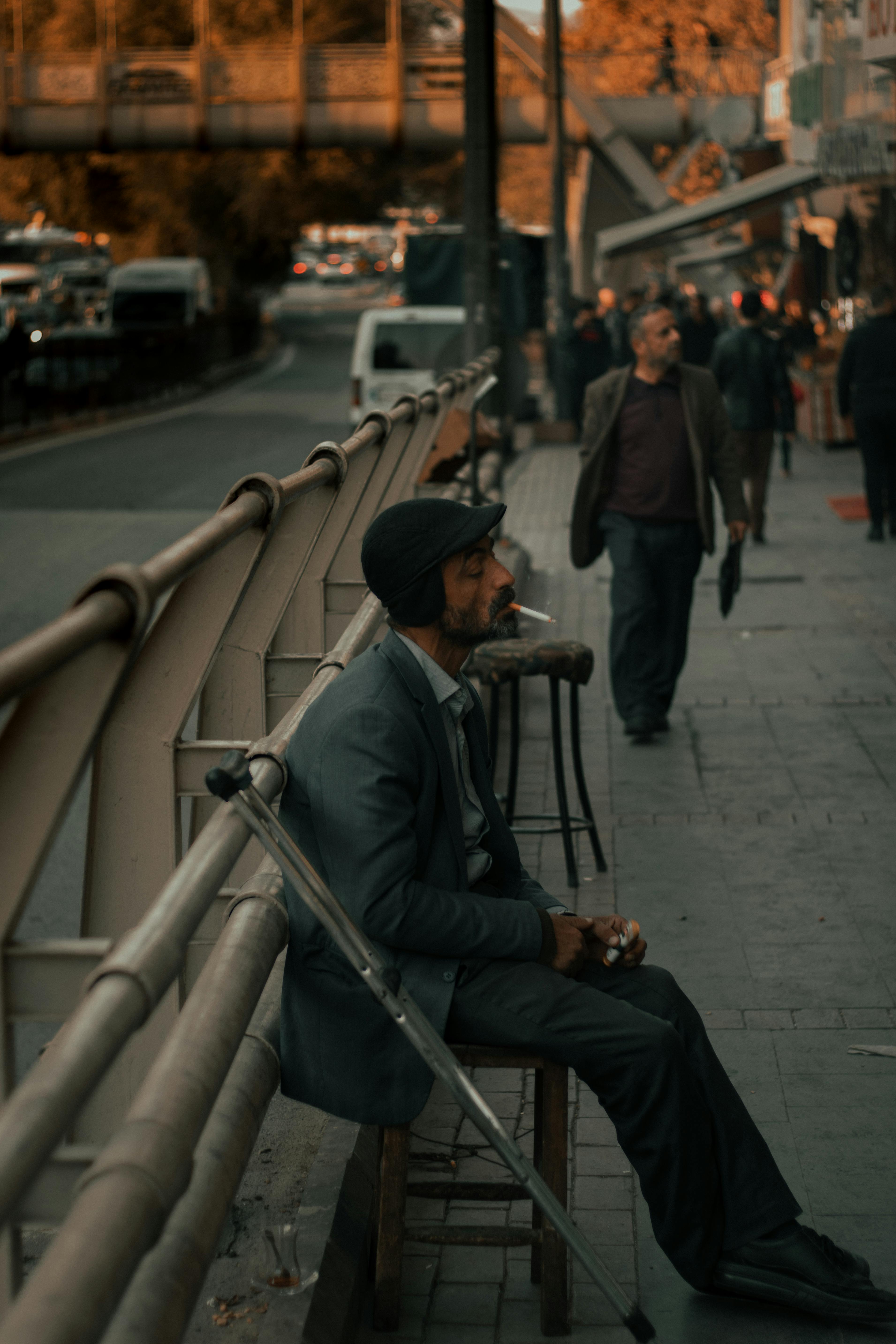 pensive ethnic man smoking cigarette on street