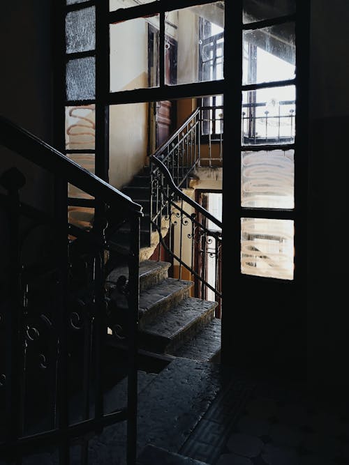 Stairwell interior inside of ancient historical residential building with metal railings and weathered steps