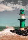 Green and White Lighthouse on Brown Rock Formation Beside Sea
