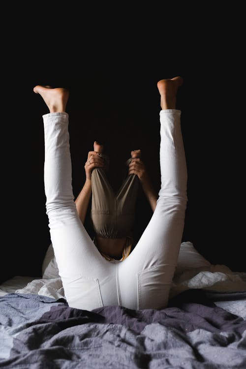 Father and Child Lying on Bed with their Legs up 