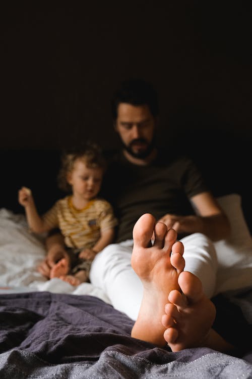 A Father and his Child Sitting on Bed 