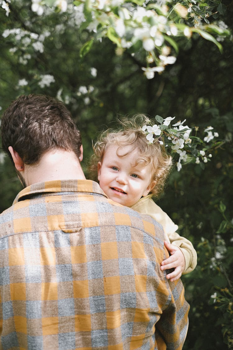 Back View Of A Father Carrying His Child 