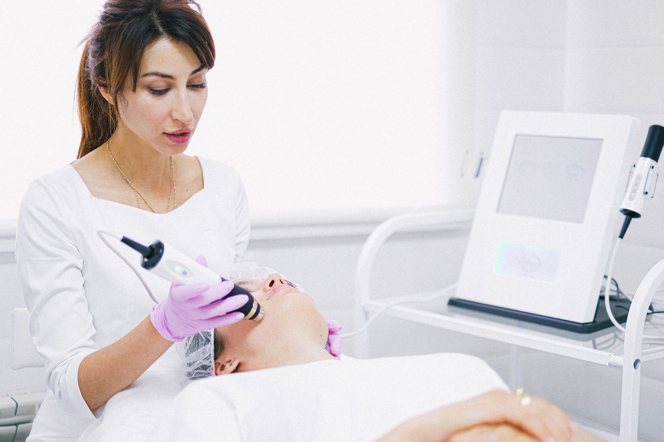 Woman receiving facial laser treatment at medical spa clinic