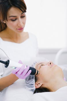A cosmetologist uses a laser device for a facial treatment on a woman lying indoors.