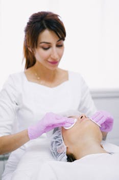 Cosmetologist performing a relaxing facial treatment in an aesthetic clinic setting.