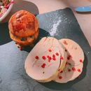 From above of delicious cut meatloaf served on black slate plate with appetizing crispy burger and decorated with pomegranate seeds