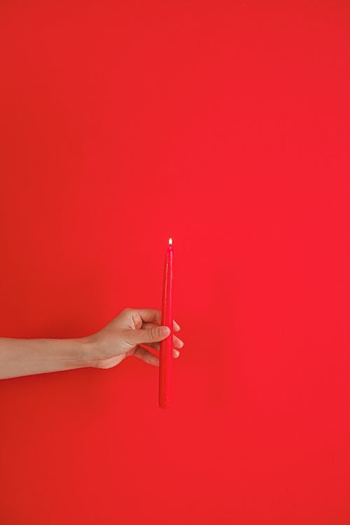 Person Holding Red Candle