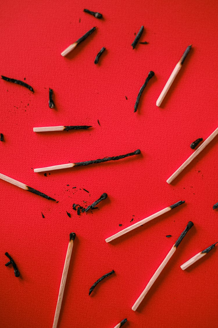 Burnt Matches On Red Surface