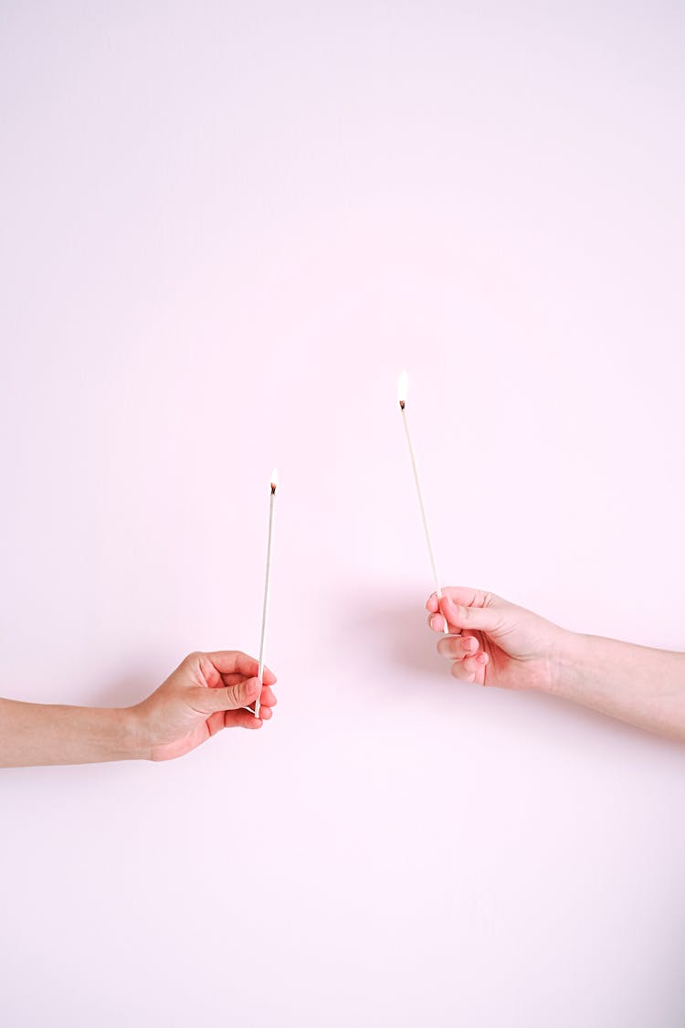 People Holding Sticks On White Surface