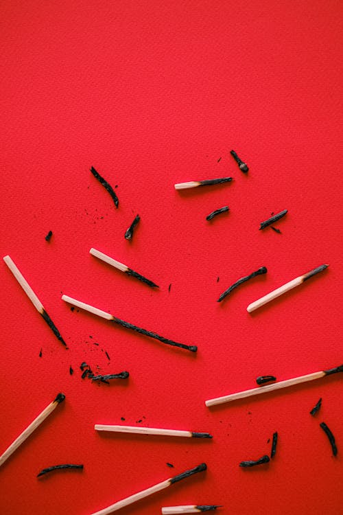 Burnt Match Sticks on red Surface 