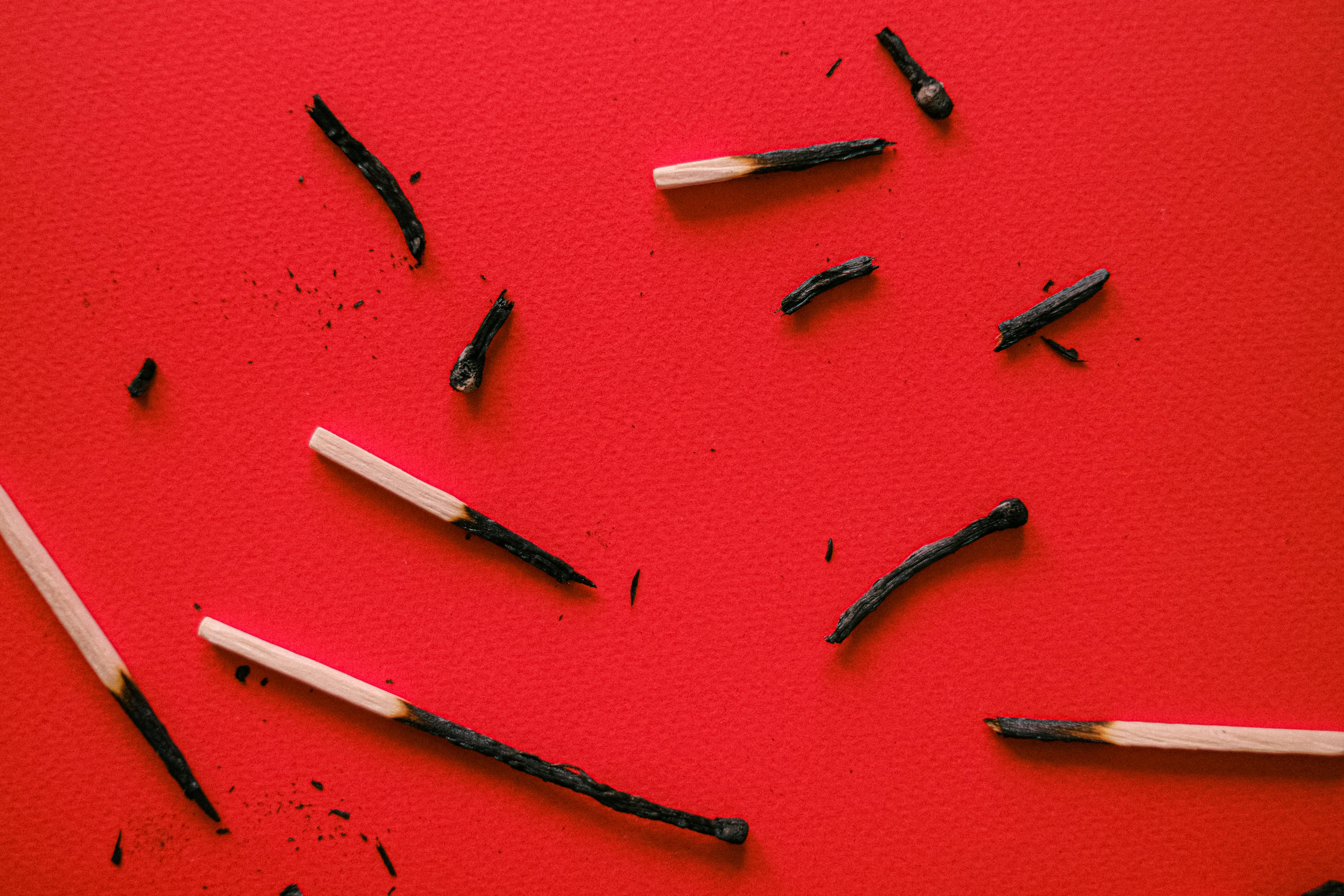 burnt match sticks on red surface