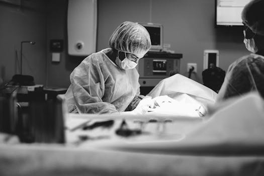 Surgeons performing an operation in a grayscale operating room setting.