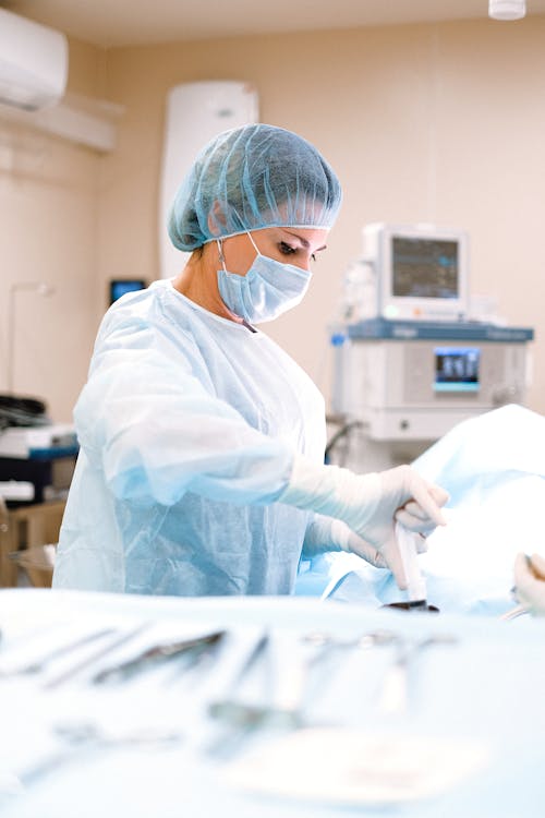 Person in Blue Scrub Suit Wearing Blue Mask