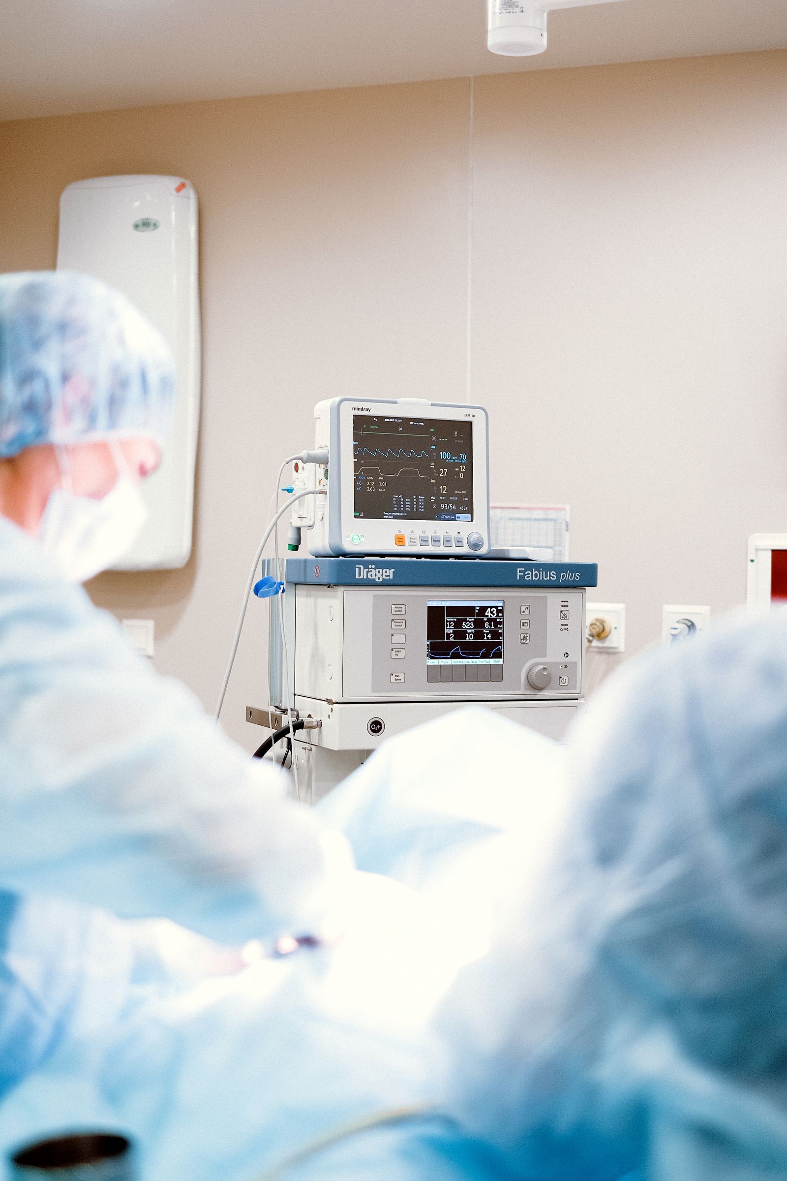 Medical professionals working with operating room equipment