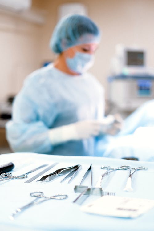 A Person in Blue Scrub Suit Wearing White Mask