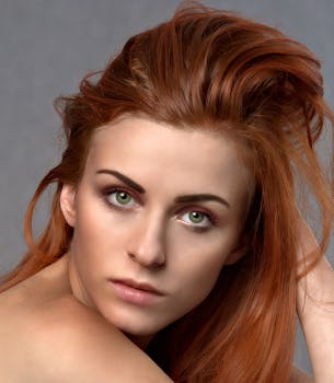特写肖像中，这位女性拥有引人注目的红发和绿眼睛，散发着优雅