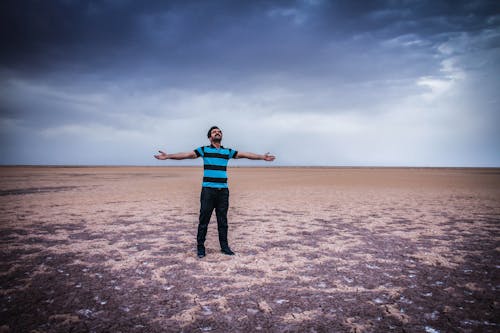 L'homme étend Ses Bras Grands Ouverts Sur Terrain