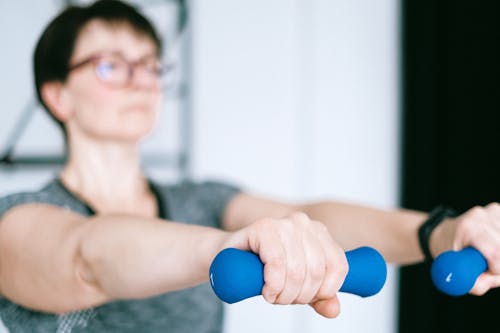Free A Woman Holding Blue Dumbbells Stock Photo