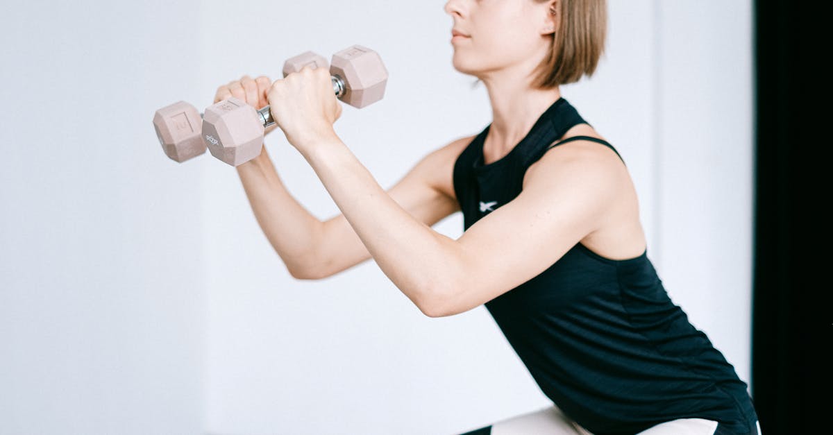 A woman performing a strength exercise with dumbbells indoors, promoting fitness and healthy lifestyle.