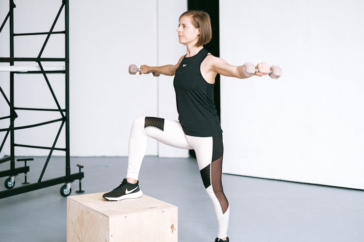 A Woman Using A Dumbbells In The Gym