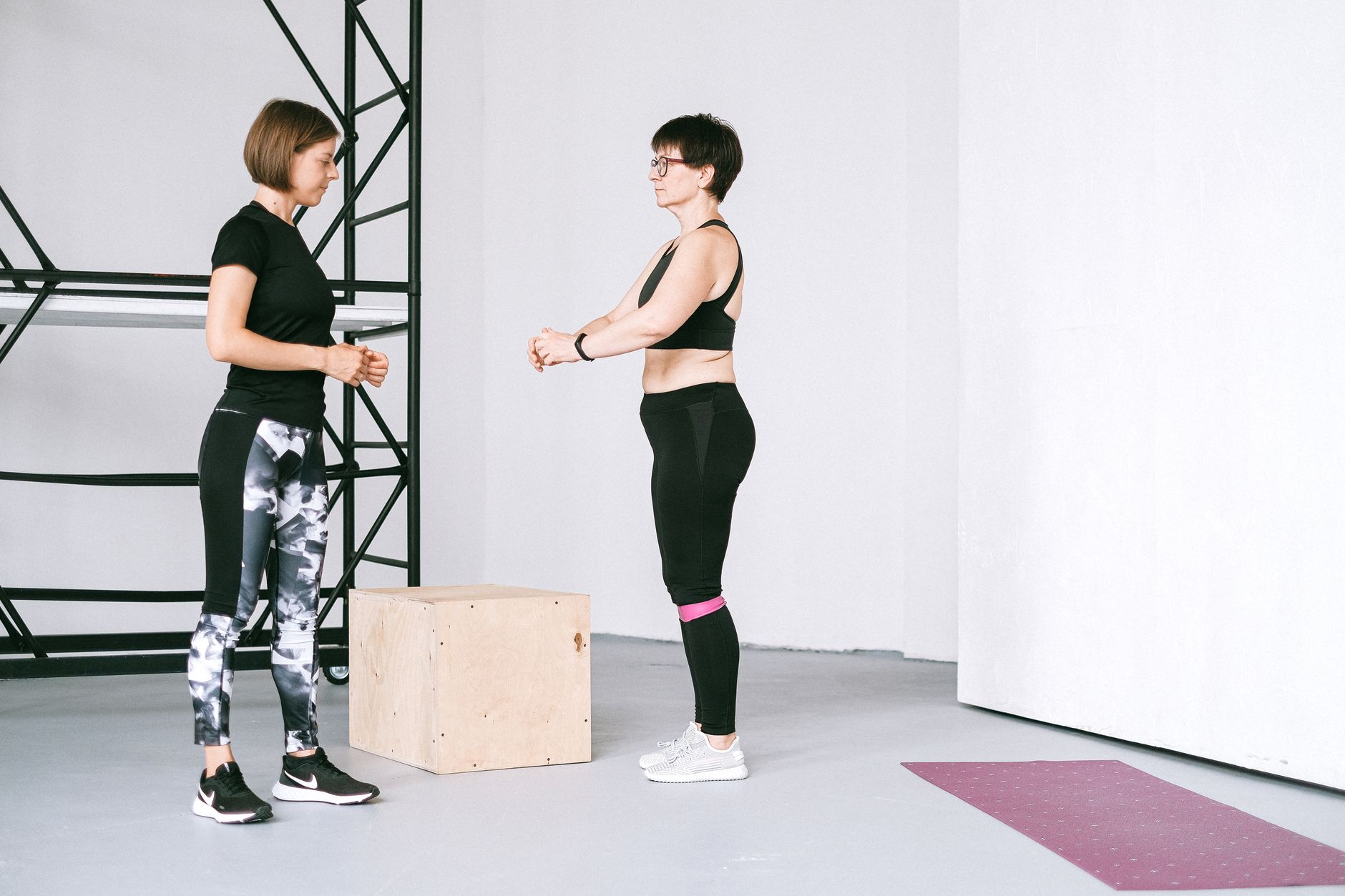 A minimalist and sophisticated private home gym with high-end equipment and floor-to-ceiling windows.