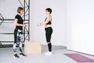 在指导下，两名女性在室内锻炼，专注于健身和健康的生活方式