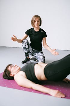 A personal trainer instructs a woman during a workout, focusing on form.