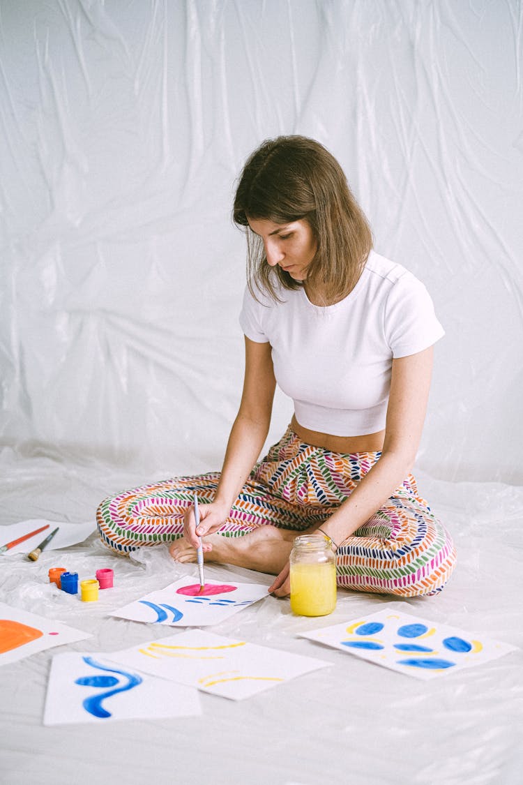 A Woman Painting With Water Colors On Paper 