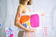 A Woman with Body Paint Holding a Painting