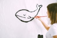 Photo of a Woman Drawing a Whale