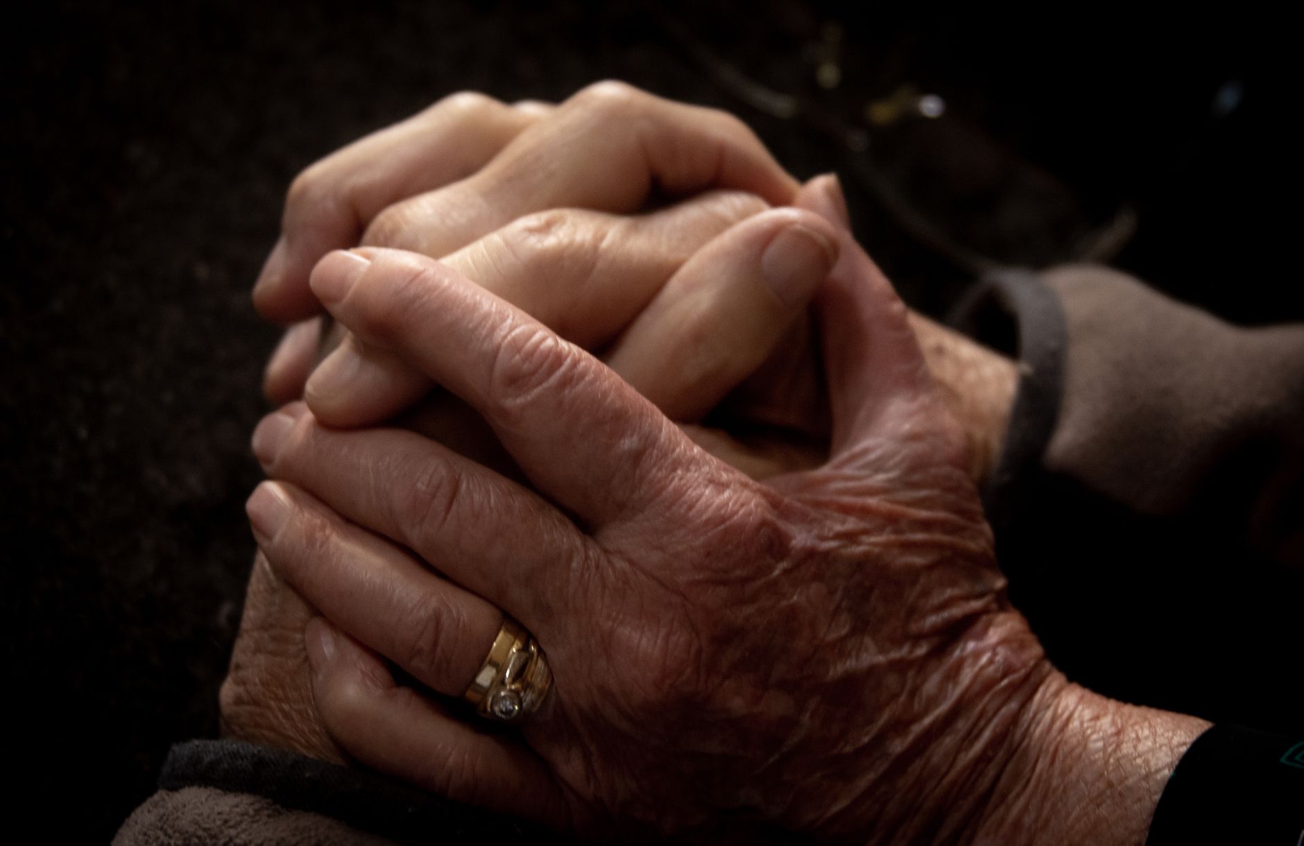 Close-up of aged and youthful hands intertwined, symbolizing connection and care.