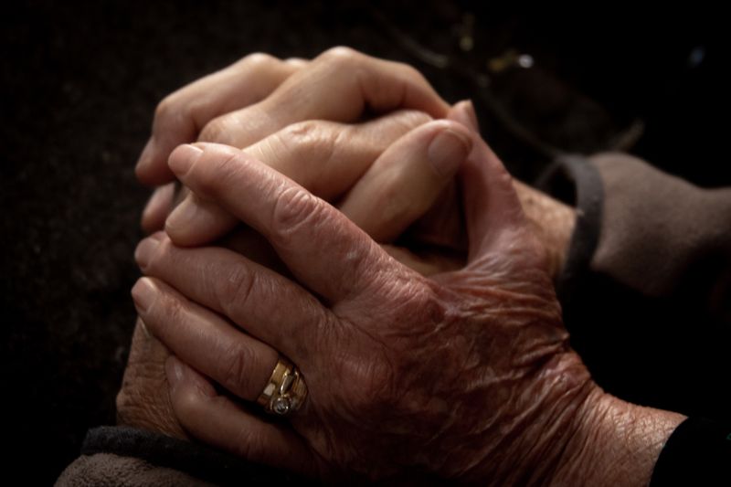 Close-up of aged and youthful hands intertwined, symbolizing connection and care.